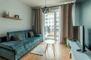 a living room with a blue couch and a window at Warsaw Inside Business Centre in Warsaw