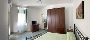1 dormitorio con 1 cama y armario de madera en La Casa dei Nonni, en Leverano