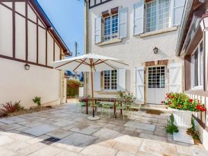 un patio con mesa y sombrilla en Villa Le Cyclamen by Interhome, en Courseulles-sur-Mer