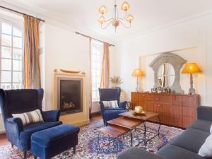 ein Wohnzimmer mit blauen Stühlen und einem Kamin in der Unterkunft Villa Le Cyclamen by Interhome in Courseulles-sur-Mer