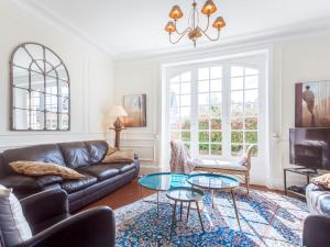 a living room with a couch and a table at Villa Le Cyclamen by Interhome in Courseulles-sur-Mer