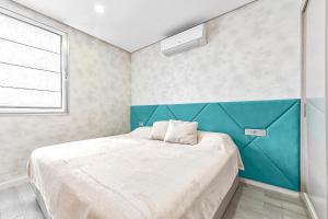 a bedroom with a large bed with a blue headboard at Ocean Garden 2 Bed Apartment in Adeje