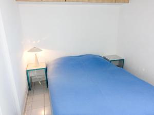 a bedroom with a blue bed and two tables at Apartment Savanna Beach I-2 by Interhome in Cap d'Agde