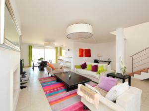 a living room with white furniture and a colorful rug at Holiday Home Île St Martin by Interhome in Cap d'Agde