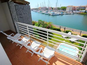a balcony with white chairs and a view of a harbor at Holiday Home Île St Martin by Interhome in Cap d'Agde