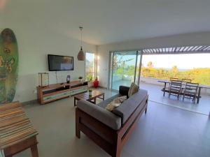 a living room with a couch and a television at Apartamentos no Pipa Residence in Pipa