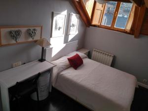 a small bedroom with two beds and a television at EDIFICIO ARDILLAS in Benasque