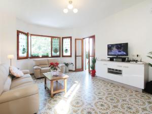 a living room with a couch and a tv at Villa Sandra by Interhome in Forte dei Marmi