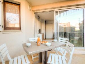 a table and chairs in a room with a window at Apartment Résidence Capao-1 by Interhome in Cap d'Agde