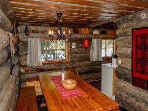 a dining room with a wooden table in a log cabin at Holiday Home Kelo-ville by Interhome in Luosto