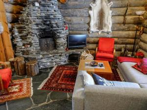 Cabaña de madera con sala de estar con chimenea de piedra. en Holiday Home Kelo-ville by Interhome en Luosto