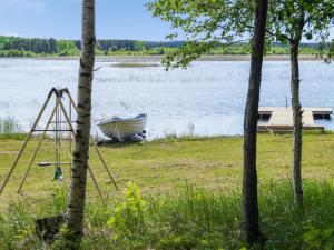 un bateau assis sur la rive d'un lac dans l'établissement Holiday Home Huvilakoti 1 by Interhome, à Puromäki