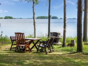 Holiday Home Huvilakoti 1 by Interhome في Puromäki: طاولة وكراسي للتنزه أمام البحيرة