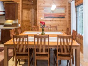 a dining room table with chairs and a vase of flowers at Holiday Home Vuosselin trio a by Interhome in Ruka