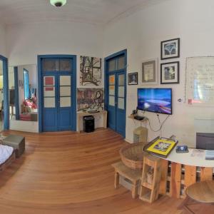 Brasileranza Hostel في نيتيروي: غرفة معيشة بأبواب زرقاء وطاولة