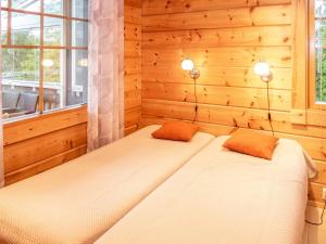 twee bedden in een kamer met houten wanden en ramen bij Holiday Home Vuosselin trio c by Interhome in Ruka