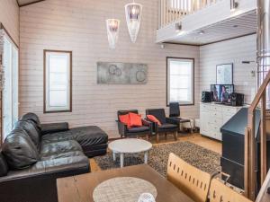 ein Wohnzimmer mit einem Ledersofa und Stühlen in der Unterkunft Holiday Home Saukkotupa by Interhome in Ruka