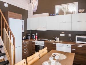 eine Küche mit weißen Schränken und einem Holztisch in der Unterkunft Holiday Home Saukkotupa by Interhome in Ruka