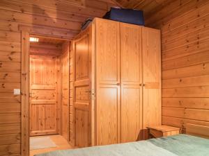 1 dormitorio con armarios de madera y 1 cama en una cabaña en Holiday Home Lomaylläs h109 -pistopolku 1 a by Interhome en Ylläsjärvi