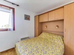 a bedroom with a bed with a yellow bedspread at Apartment Plein Soleil-1 by Interhome in Cap d'Agde