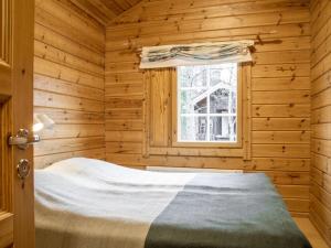 a log cabin bedroom with a bed and a window at Holiday Home Lomaylläs h113-pistopolku 5a by Interhome in Ylläsjärvi +13 photos