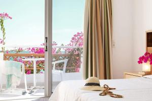 a teddy bear sitting on a bed in a room with a window at MINOS BEACH KARPATHoS in Karpathos Town