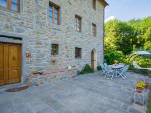 a patio with a table and chairs in front of a stone building at Holiday Home Il Vecchio Ospitale by Interhome in Aramo