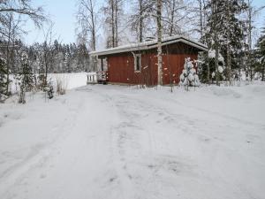 Juhanala的住宿－Holiday Home Lepikko by Interhome，一条雪覆盖的道路,通往红色小屋