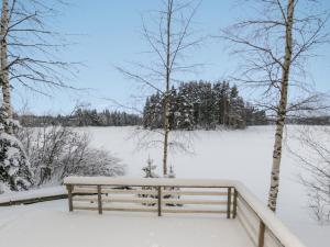 a bench covered in snow next to a fence at Holiday Home Piilopirtti by Interhome in Juhanala