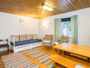 a room with a bed and chairs and a table at Holiday Home Piilopirtti by Interhome in Juhanala