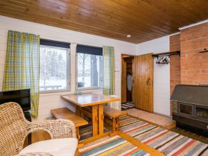 a living room with a table and a fireplace at Holiday Home Piilopirtti by Interhome in Juhanala +11 photos