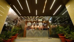 a restaurant with potted plants in front of a bar at New Hotel Suhail in Hyderabad