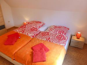une chambre avec deux lits avec des serviettes rouges dessus dans l'établissement Apartment Landblick-2 by Interhome, à Süderneuland Zwei 12 autres photos
