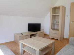 - un salon avec une télévision et une table en bois dans l'établissement Apartment Landblick-2 by Interhome, à Süderneuland Zwei