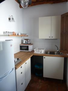 una cocina con armarios blancos y fregadero en Casita de la Vaca, en Mondújar