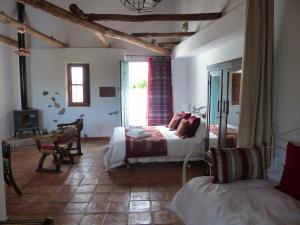 a bedroom with two beds and a table and a fireplace at Casita de la Vaca in Mondújar