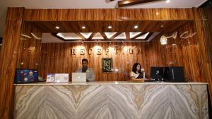 a man and woman sitting at a reception desk at New Hotel Suhail in Hyderabad