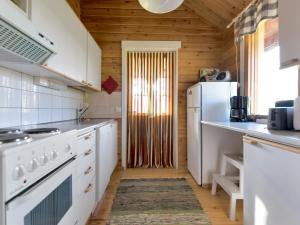 PetäjävesiにあるHoliday Home Kuusikumpu by Interhomeの木製の天井、白い家電製品付きのキッチン