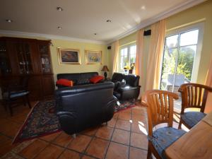 a living room with a black leather couch and chairs at Holiday Home Fischerhaus by Interhome in Groß Zicker