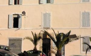 - un grand bâtiment avec des fenêtres et des palmiers devant dans l'établissement Hôtel de la Renaissance, à Marseille