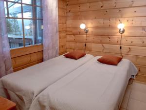 a bedroom with a bed with two pillows on it at Holiday Home Vuosselin trio b by Interhome in Ruka