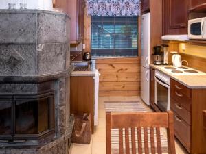a kitchen with a fireplace and a chair in it at Holiday Home Vuosselin trio b by Interhome in Ruka