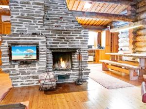a stone fireplace in a living room with a tv at Holiday Home Olokolo 2 by Interhome in Nissi