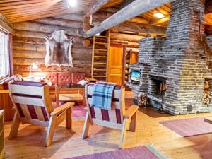 a log cabin living room with a stone fireplace at Holiday Home Olokolo 2 by Interhome in Nissi
