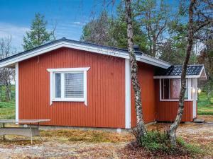 a red house with a bench in front of it at Holiday Home Mellaniemi by Interhome in Hietajoensuu