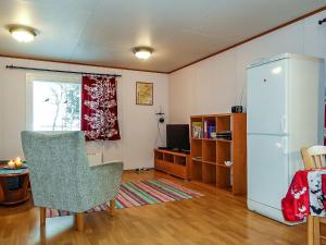 a living room with a refrigerator and a chair at Holiday Home Mellaniemi by Interhome in Hietajoensuu