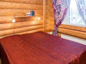 ルカにあるHoliday Home Rukan lepolinna b by Interhomeの木製の部屋に赤いベッドが備わるベッドルーム1室