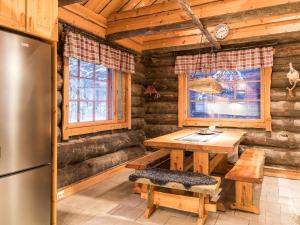 a kitchen with a table and a refrigerator in a log cabin at Holiday Home Operonmukka a 8 by Interhome in Levi