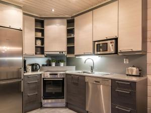 a kitchen with stainless steel appliances and wooden cabinets at Holiday Home Levin ahmahovi 1a by Interhome in Levi