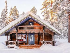 une cabane en rondins dans les bois dans la neige dans l'établissement Holiday Home Tikkatupa by Interhome, à Levi